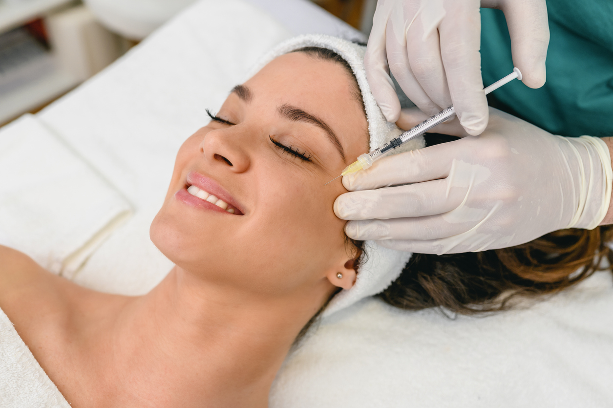 Stock photograph of models: a woman receives an injection from a gloved clinician